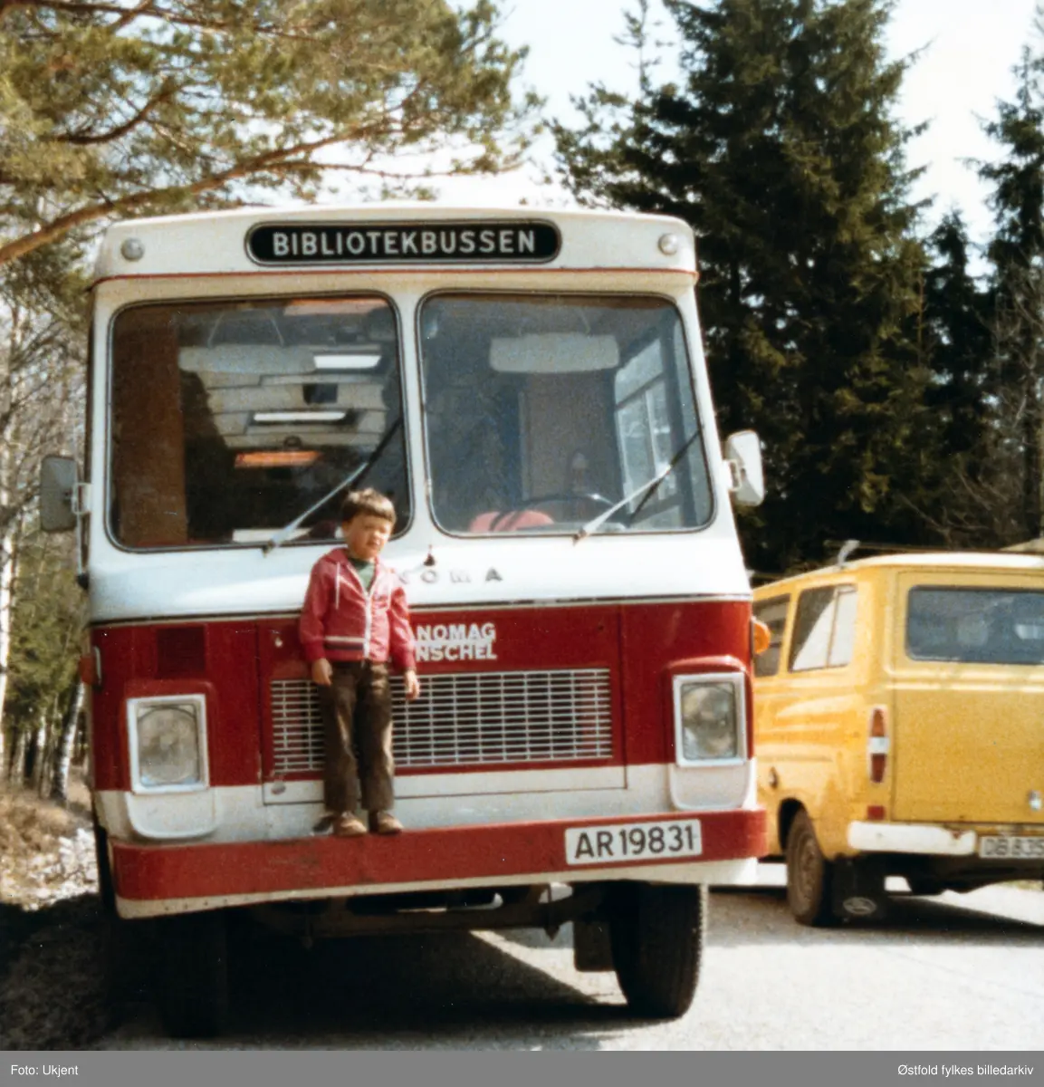 Bokbussen, biblotekbussen til Østfold fylkesbibliotek. Bilkjennetegn AR-19831 av merket Hanomag Henschel. Gutt foran bussen, Torkel.
Bussen ble innkjøpt i 1973.