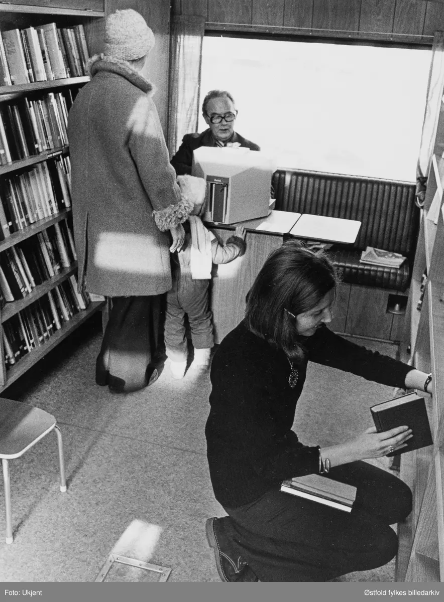 Østfold fylkesbibliotek, Østfold rullende bibliotek. Bokbussjåfør Viggo Nilsen inni bussen. Ukjent låner og bibliotekar.