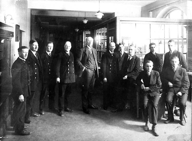 Medföljande text: "Kansli- kassapersonal vid postkontoret i Uddevalla i slutet av 20-talet. Uddevalla postkontorhistorik sedan början av 1800-talet".