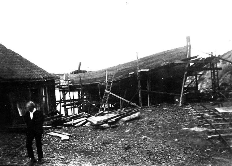 Medföljande text: "Myrens Mekaniska Verkstad, Strömstad. Fraktfartyget "Norrviken" under byggnad (se även R 59:2, R 59:3, R 59:4, R 60:3). På bilden syns Karl-Erik Andersson, Strömstad (arbetade ej vid verkstaden). Bilden tagen 1931-1932. Originalfoto tillhörande Allan Ljungqvist, Strömstad".