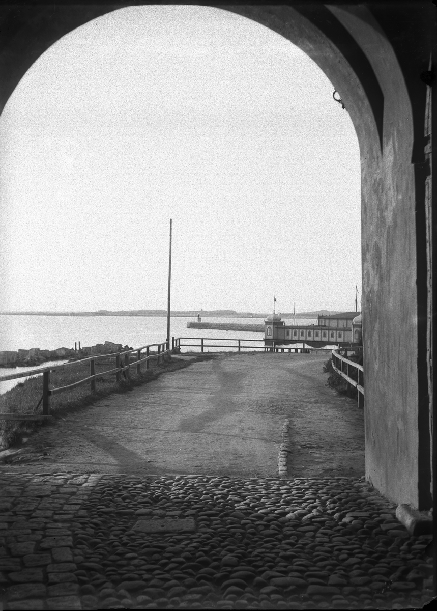 Vy från en av fästningsportarna mot hamnen och kallbadhuset, som skymtar till höger.
