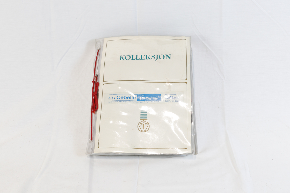 Hvit perm med rød innbindingstråd på siden. På forsiden av permen står det "Kolleksjon". Permen innholder hefter/lommer i plast med vareprøver.