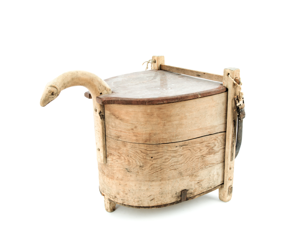 Loket er raudmåla og er innfelt i handtaket og den flate bakplata. Eit lærbelte er fest til hjørnestolpane som berereim.
Øvre enden av handtaket er utforma som eit dyrehovud (kanhende ein ver) med horn.