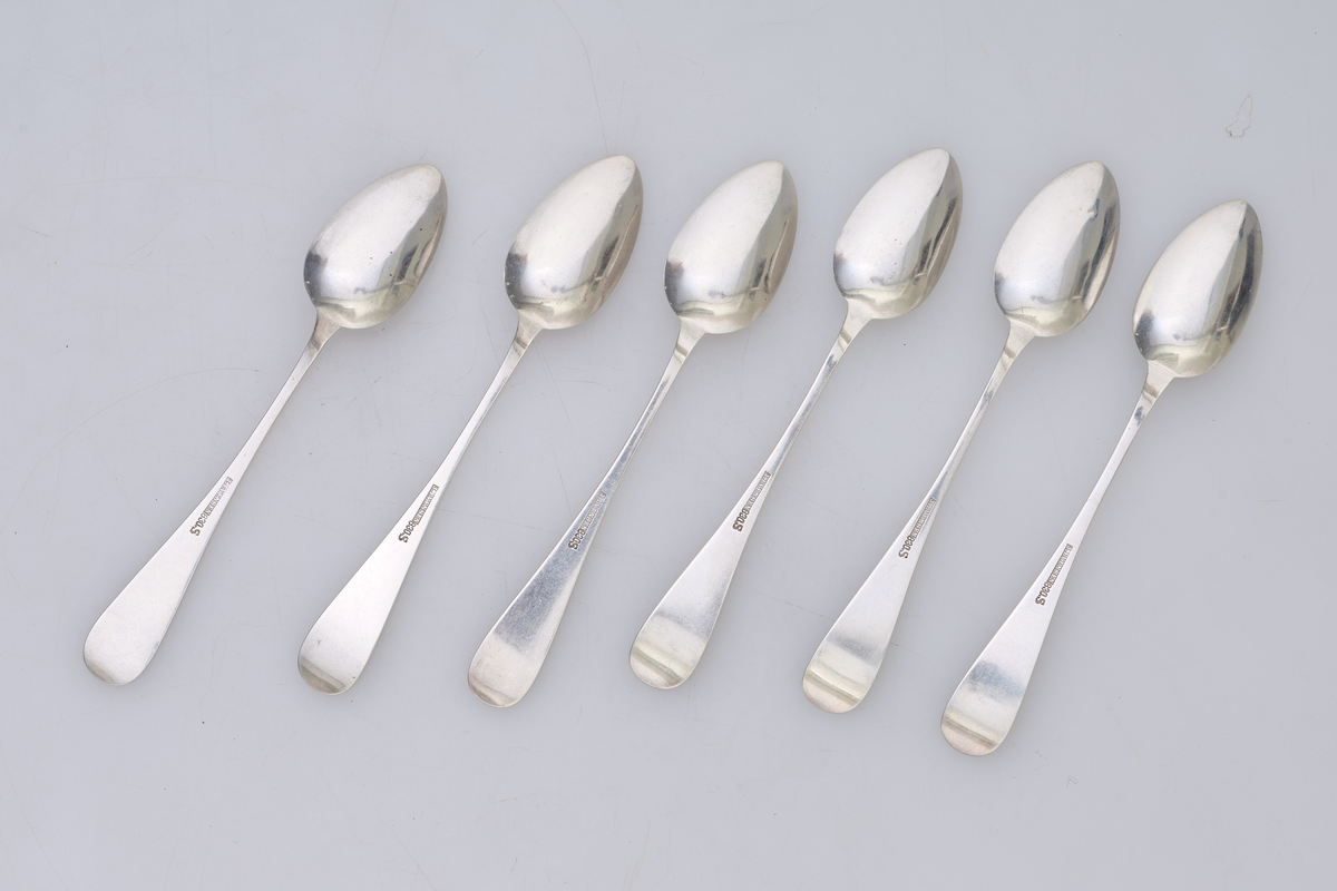 Seks teskjeer i sølv med dekorert håndtak.
