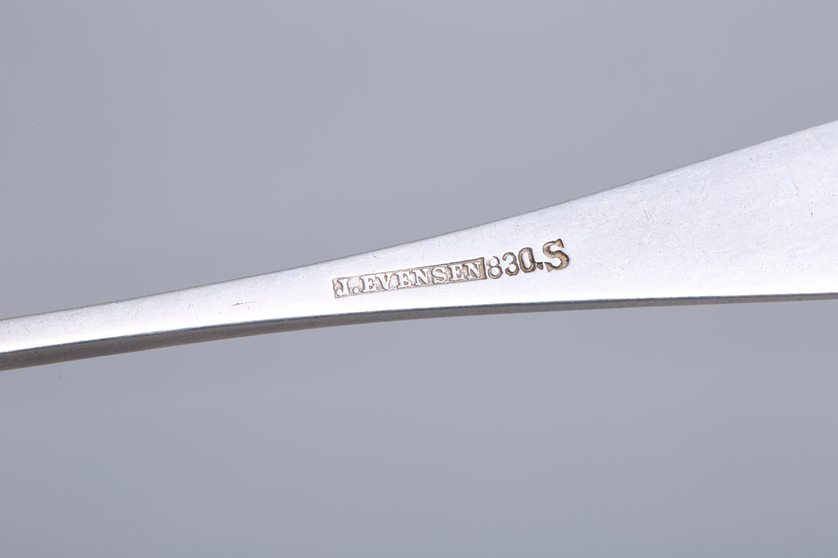 Seks teskjeer i sølv med dekorert håndtak.