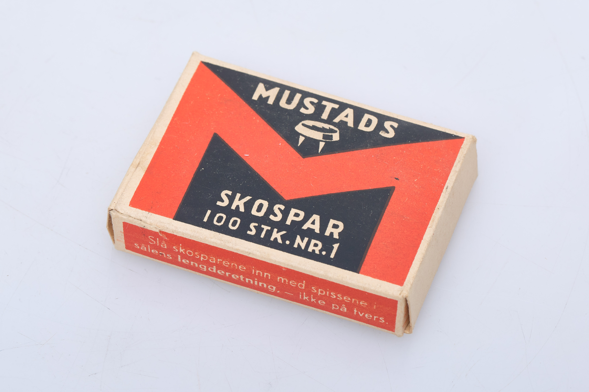 Eske til å ha skospar i. Esken har teksten Mustads Skospar 100 stk. Nr. 1