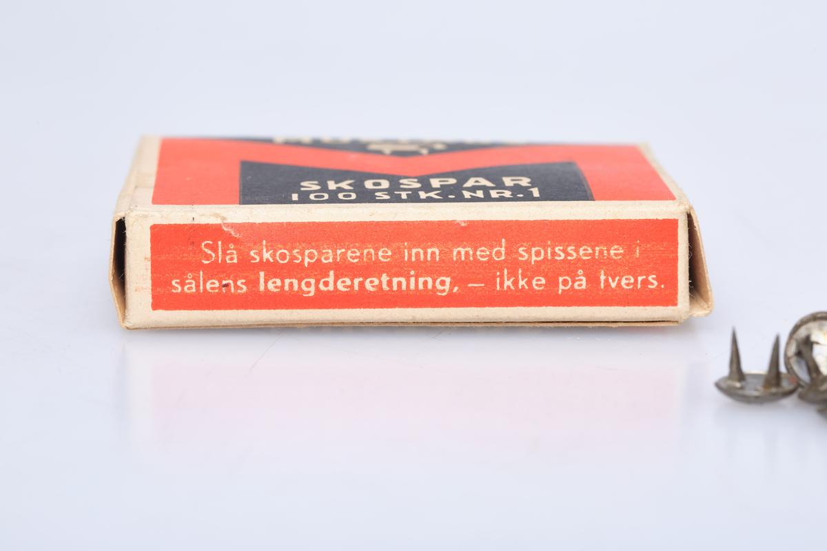 Eske til å ha skospar i. Esken har teksten Mustads Skospar 100 stk. Nr. 1