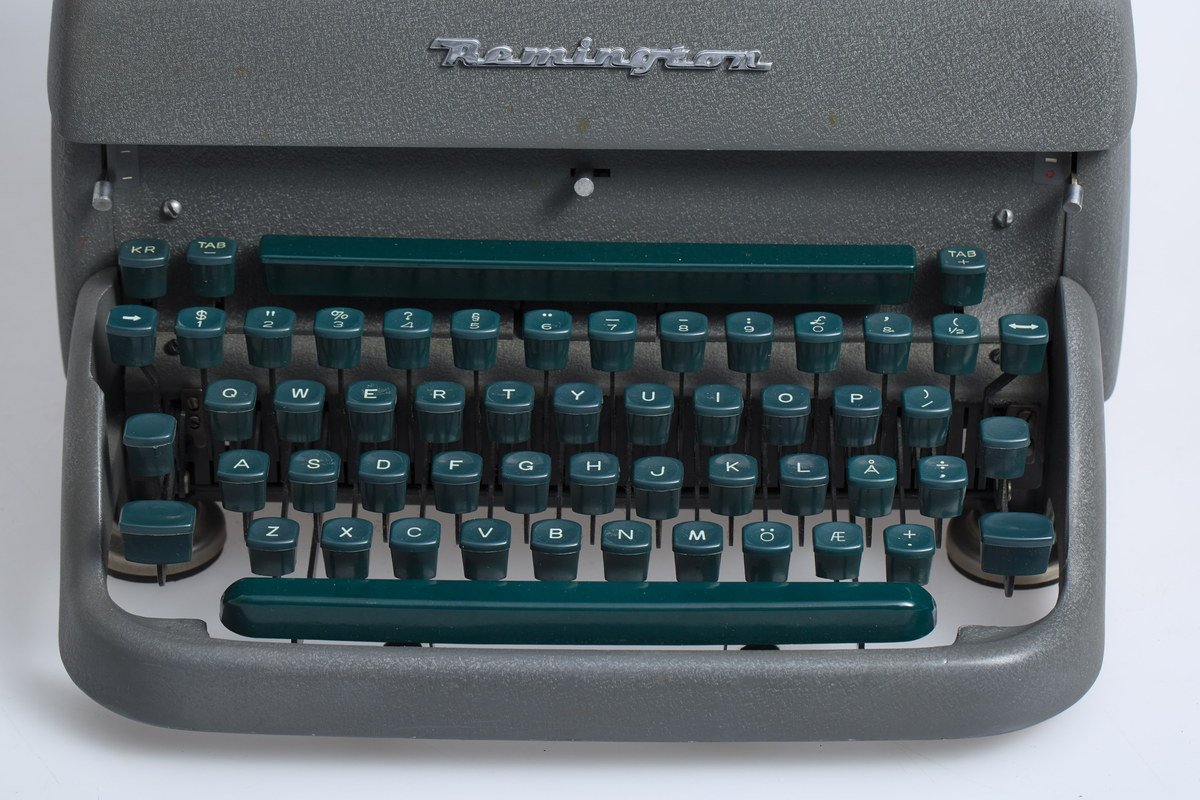 Grågrønn skrivemaskin av type Remington Rand. Grønt tastatur. Produsert (montert sammen) på Kapp Melkefabrikk i 1950 åra.