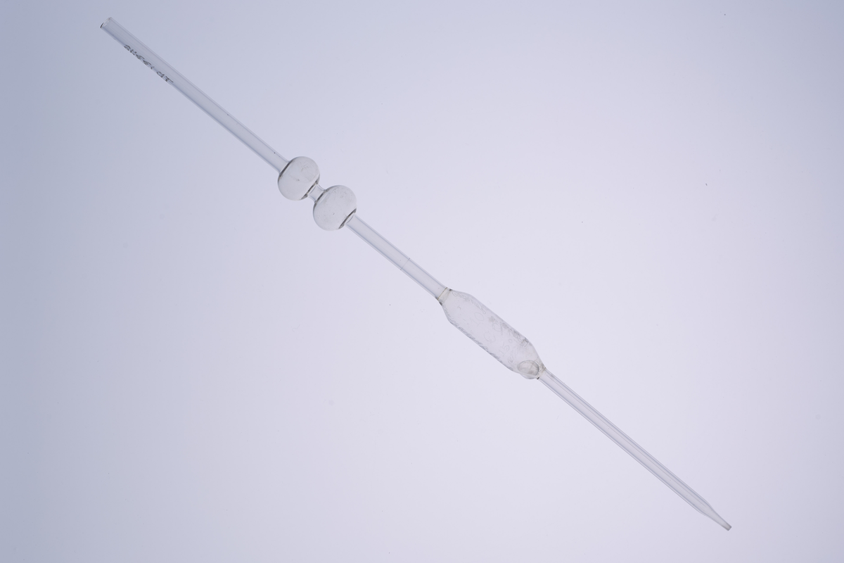 Volumetrisk pipette på 10ml, laget av glass med tre utblåsninger. Den har et smalt glassrør med to runde utblåsninger, og har en tydelig utblåsning midt på, som markerer det nøyaktige volumet den er kalibrert for. Den har en bredere åpning øverst for å suge opp væske, og en tynn, presis spiss nederst for å dryppe ut væsken. Pipetten brukes i laboratorier til å måle opp og overføre en nøyaktig mengde væske. 

Denne er enten brukt på Kapp Melkefabrikker eller ved Nestlés fabrikk på Hamar.