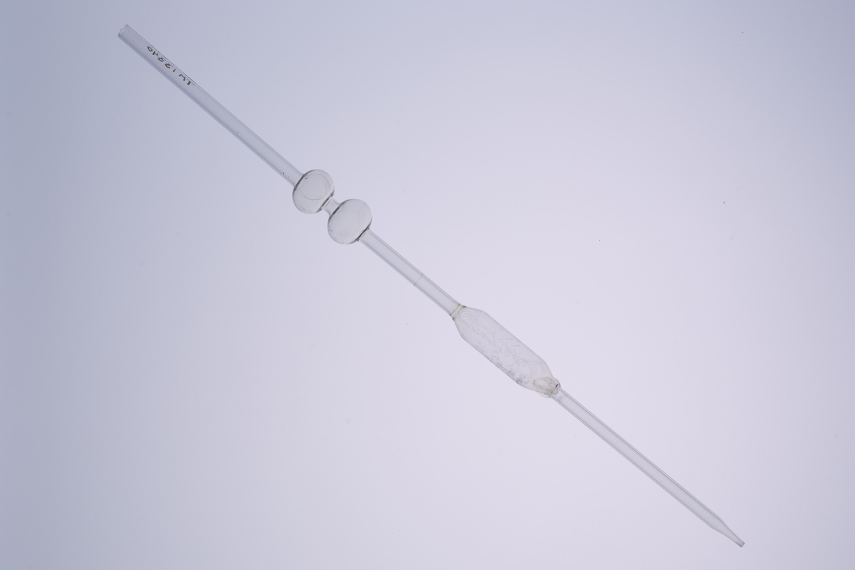 Volumetrisk pipette på 10ml, laget av glass med tre utblåsninger. Den har et smalt glassrør med to runde utblåsninger, og har en tydelig utblåsning midt på, som markerer det nøyaktige volumet den er kalibrert for. Den har en bredere åpning øverst for å suge opp væske, og en tynn, presis spiss nederst for å dryppe ut væsken. Pipetten brukes i laboratorier til å måle opp og overføre en nøyaktig mengde væske. 

Denne er enten brukt på Kapp Melkefabrikker eller ved Nestlés fabrikk på Hamar.