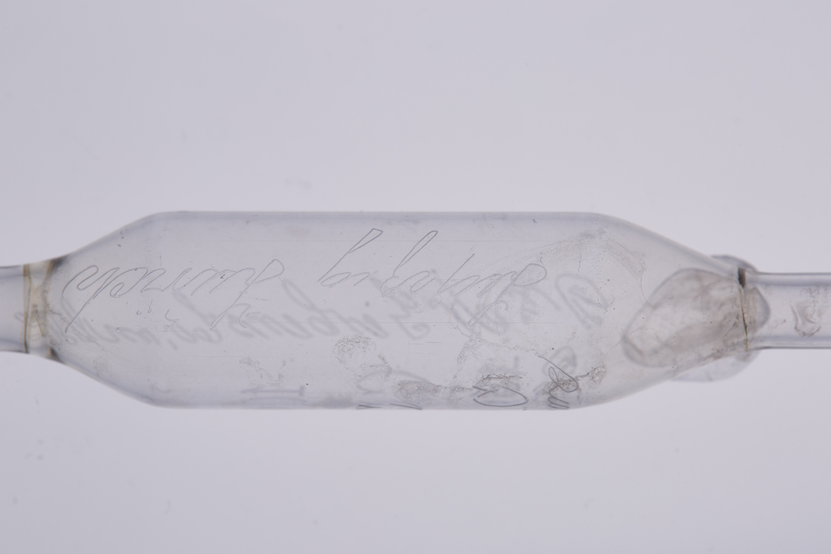 Volumetrisk pipette på 10ml, laget av glass med tre utblåsninger. Den har et smalt glassrør med to runde utblåsninger, og har en tydelig utblåsning midt på, som markerer det nøyaktige volumet den er kalibrert for. Den har en bredere åpning øverst for å suge opp væske, og en tynn, presis spiss nederst for å dryppe ut væsken. Pipetten brukes i laboratorier til å måle opp og overføre en nøyaktig mengde væske. 

Denne er enten brukt på Kapp Melkefabrikker eller ved Nestlés fabrikk på Hamar.