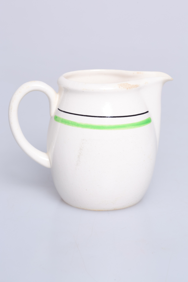 Fløtemugge fra Stavangerflint, serien heter "Glatt", hvit base, grønn rand med sort linje. Designet er av Thorbjørn Feyling.