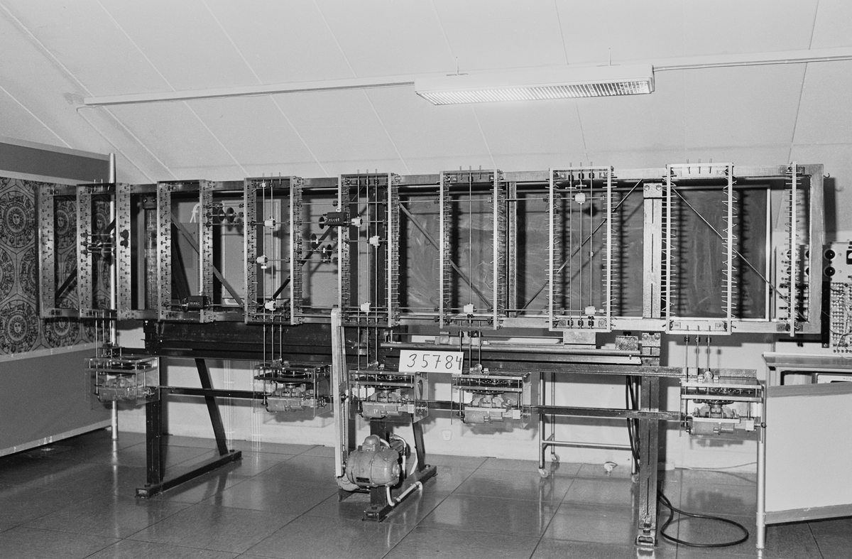 Mekanisk differentialanalysator. Differentialekvationer löses genom en ett mekaniskt system, drivet av elmotorer. Föremålet demonterat och består av TM35784-TM35859.