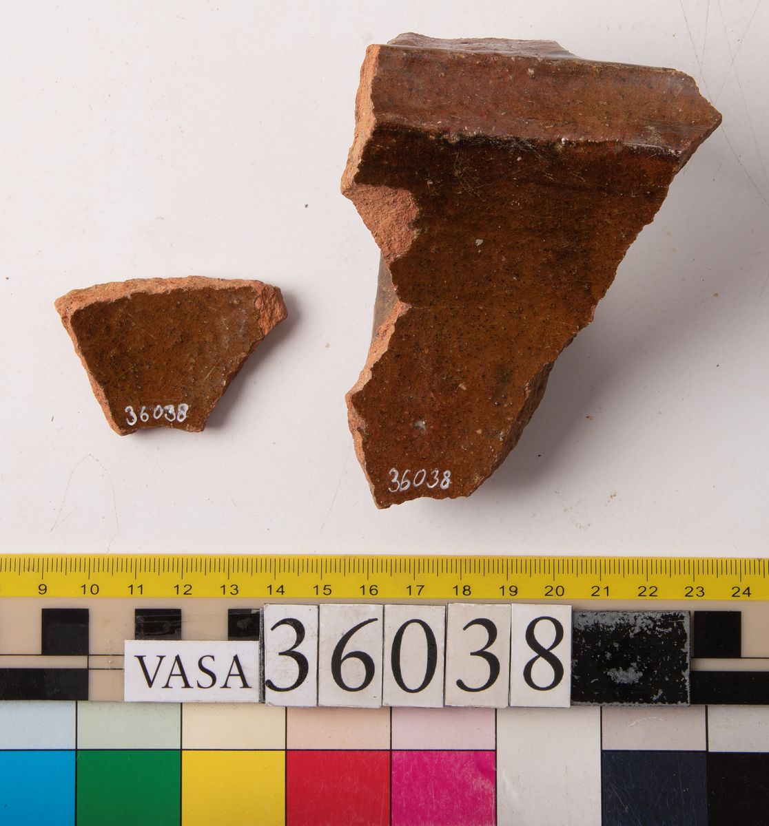 1 st bandhänkel och del av mynningsrand och skuldra. Fragment (hopsatt av 2 bitar). Insida blyglaserad brun. Utsida oglaserad.
