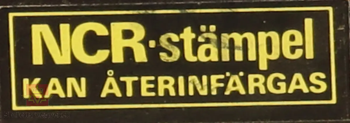 Stempel av plast og stempelplaten er av gummi. Rektangulært, svart stempel med rødt håndtak. På framsiden av stempel står stempel typen i gul skrift. Stempelplaten er blåfarget pga. blekk. 