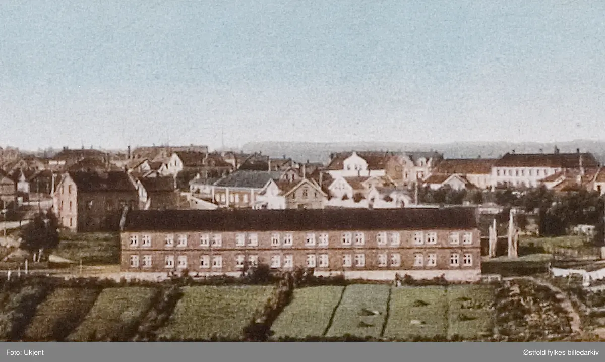 Kolorert panorama fra Sarpsborg, to felt. 
Øverste panorama med vestre bydel med Sarpsborg kirke, Festiviteten, Kullåsparken, middelskolen, Sannesundveien skole. 
Nederste panorama med østre bydel med Metodistkirken, Kirkegaten skole, St. Olavs Vold, luftbanen, i bakgrunnen Borregaardkrana og tømmerlageret på Opsund.
To utsnitt, bilde 2 og 3 (St. Olavs Vold).