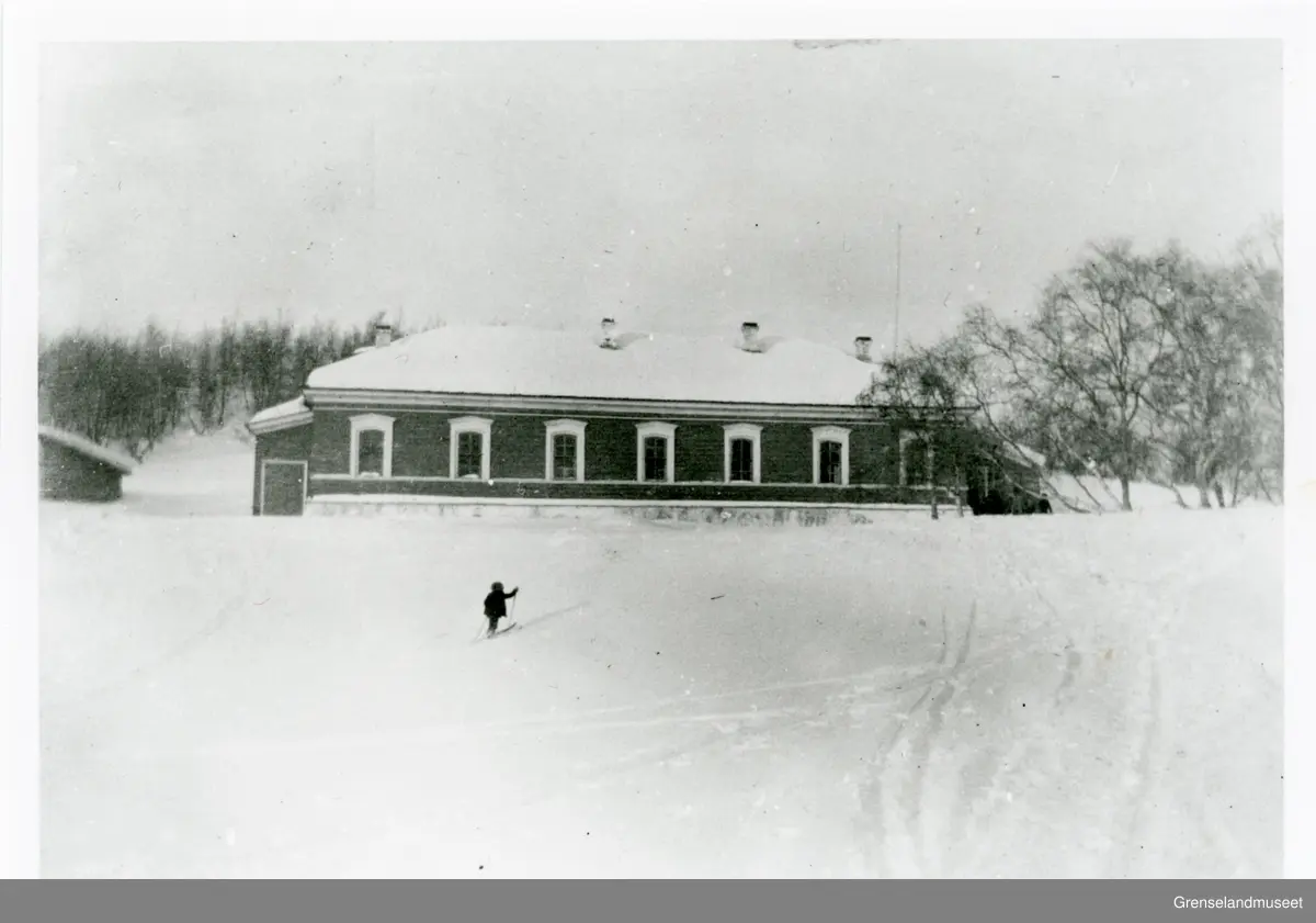 Prestegården i Boris Gleb. Et barn går på ski opp bakken mot prestegården. 