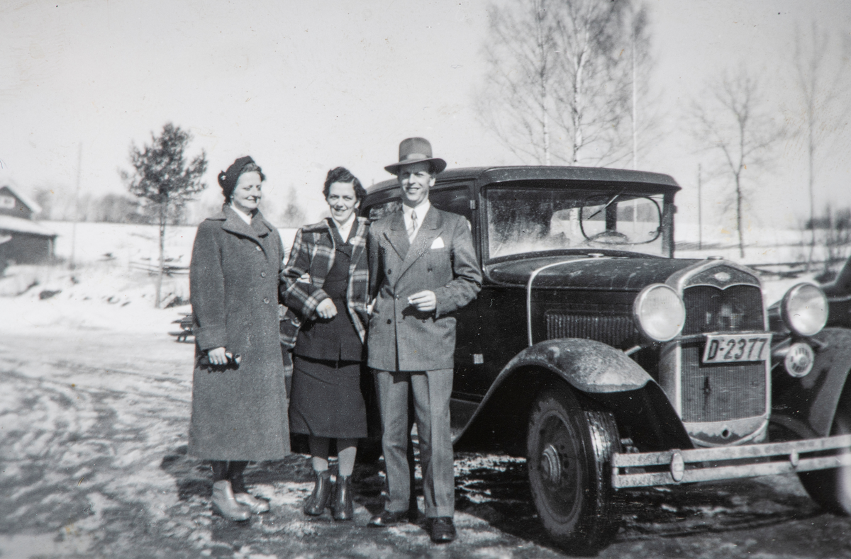 Stange, Ford A-modell, årsmodell 1931 med nyere felger og "frostrute" for å holde det viktigste av sjåførens synsfelt isfritt, 3 personer stående ved en bil med registreingsnummer D-2377