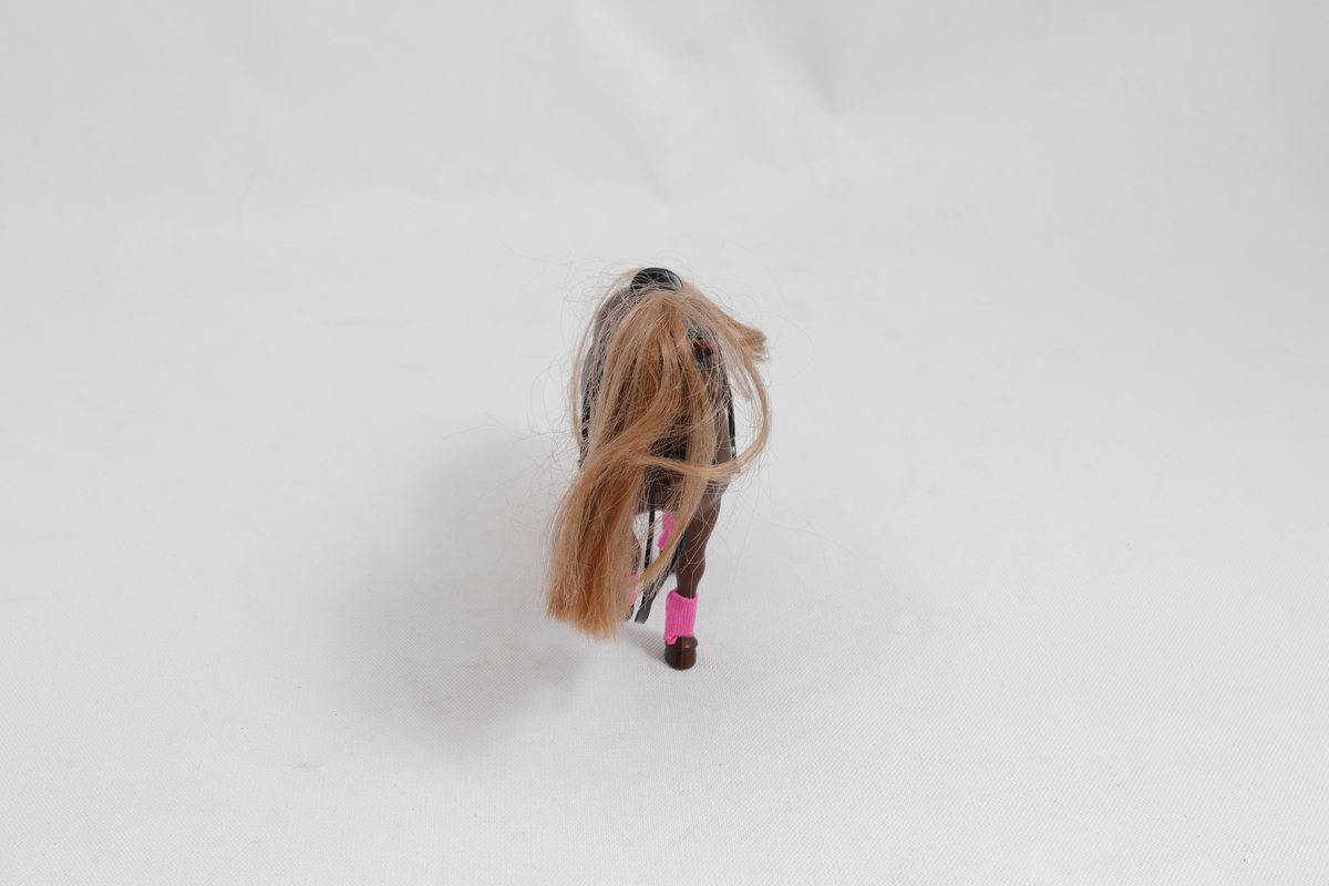 Leke. Brun lekehest med lysebrun man, svart sal og rosa tøy nederst på beina. 