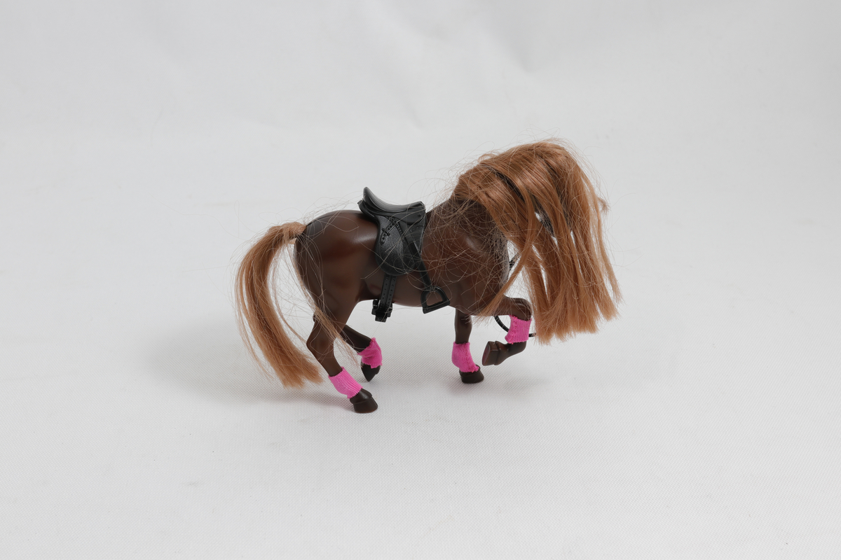 Leke. Brun lekehest med lysebrun man, svart sal og rosa tøy nederst på beina. 