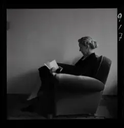 Porträtt av fotografens mor som sitter i en fåtölj och läser