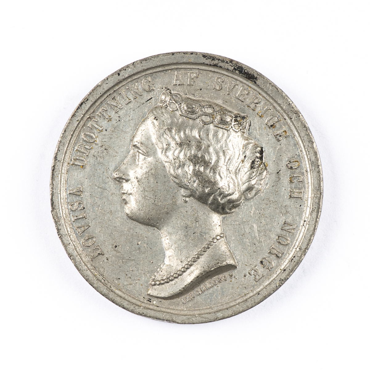 Medalj, minnesmedalj i silver. Drottning Lovisas död, 1871. Porträttbild och text "LOVISA DROTTNING AF SVERIGE OCH NORGE". Frånsida med bevingad mansfigur. Text "FÖLJD AF KÄRLEK TACKSAMHET OCH SAKNAD DEN 30 MARS 1871". Graverad av Lea Ahlborn, kort efter drottningens död.