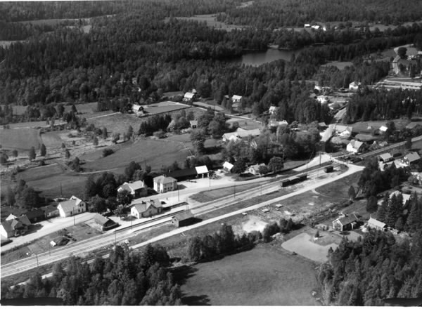 "Flygfoto över Bygget", Breared. Bilden visar bebyggelsen kring järnvägsområdet med stationsbyggnaden. Omliggande skogar, vattendrag och odlingslandskap.
