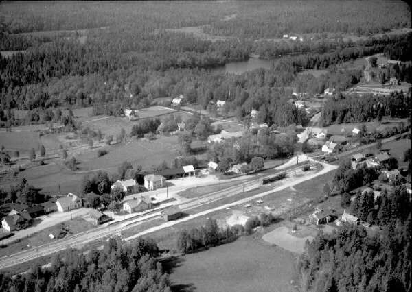 "Flygfoto över Bygget", Breared. Bilden visar bebyggelsen kring järnvägsområdet med stationsbyggnaden. Omliggande skogar, vattendrag och odlingslandskap.