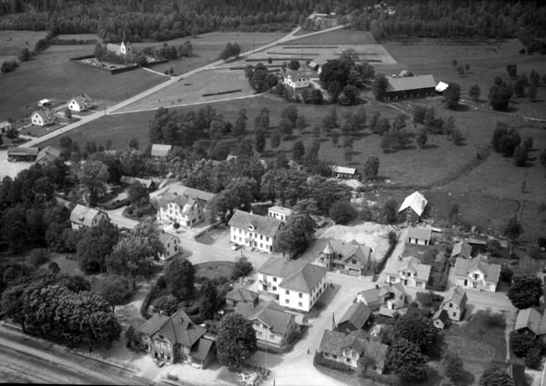 Flygfoto över Landeryd stationssamhälle. Järnvägsstationen ses nedtill och ovan den parker och varierad centrumbebyggelse. I bakgrunden Landeryds kyrka och kyrkogård på ena sidan vägen och en gård med omgivande odlingslandskap på den andra.