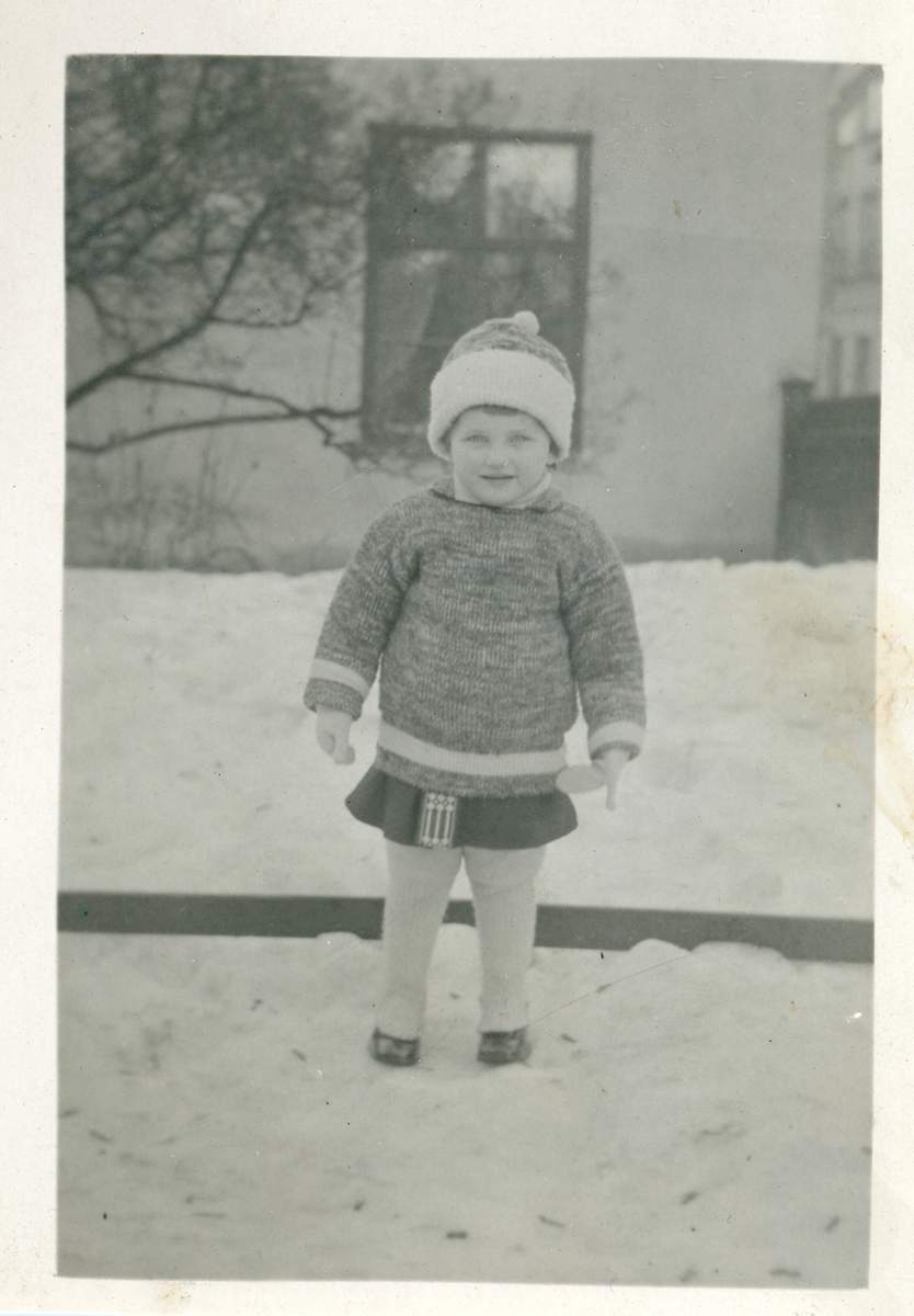 Foto av Torborg i snön (enligt text skriven i albumet). Text baksidan kort: "Tant Tora gratuleras hjärtligt af Torborg och den öfriga familjen". Adresserat till: Fru Tora Svensson, Östra Ågatan, Uppsala.