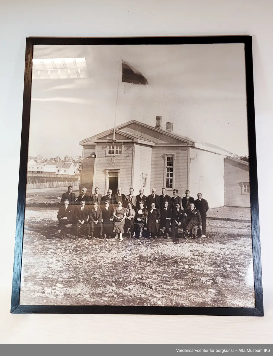 Innrammet foto av Folkets hus i Bossekop med to rekker av personer i front.