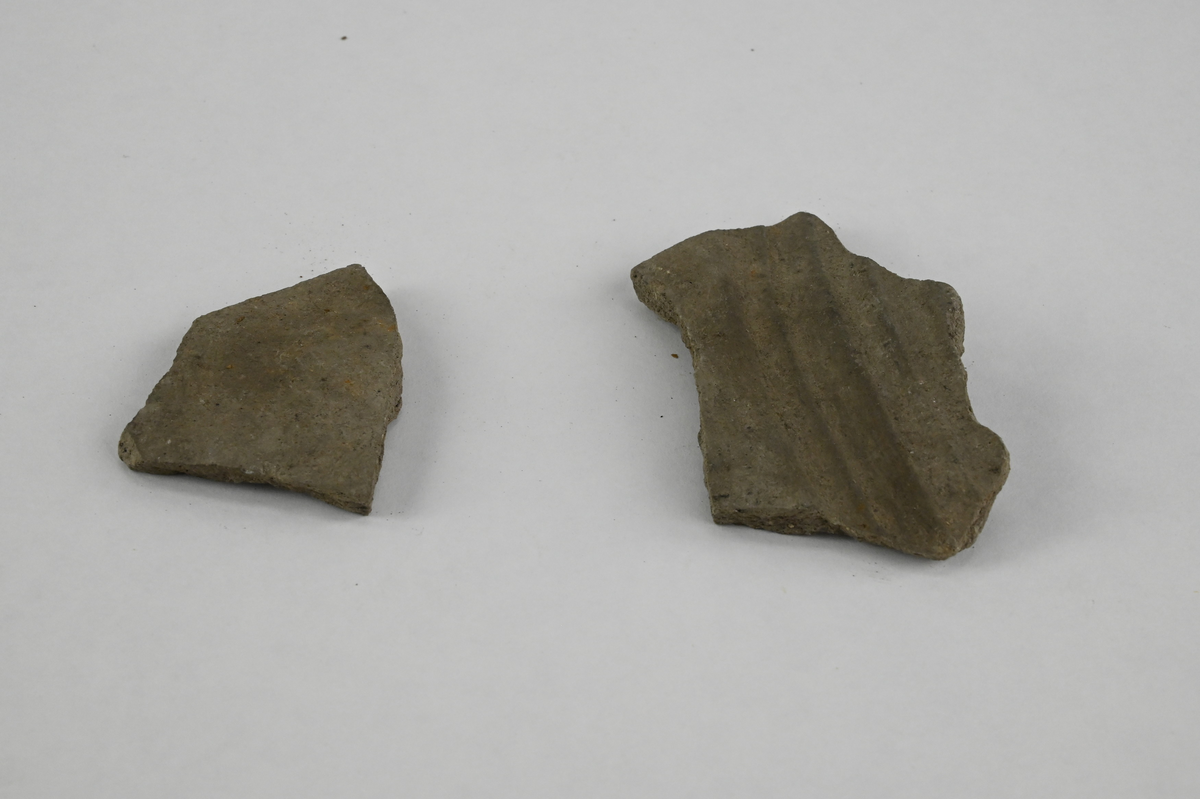 Keramik, två prover. Märkt "Keramik fr hospitalsgården. I slagglagrets nedre del. Nr 25" samt XVII. Lapp med texten: "Mj. tjockt (ej drejat?) Svartgods, ganska hårt bränt; läpp, Kälad kant"
Sammanlagd vikt: 25g.