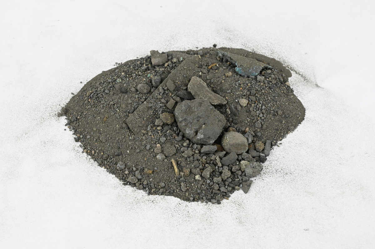 Materialprov, några smärre slaggstycken samt kopparbitar och grus. Märkt XXIV.
Storlek upp till 65 mm, sammanlagd vikt 115 g.
