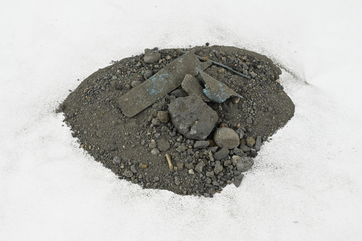 Materialprov, några smärre slaggstycken samt kopparbitar och grus. Märkt XXIV.
Storlek upp till 65 mm, sammanlagd vikt 115 g.