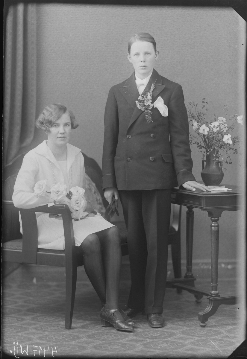 Fotografering beställd av Britta Johansson. Föreställer sannolikt syskonen Anna Britta Johansson (1914-1939) och Erik Gustaf Johansson (1915-1987). Brodern tog senare namnet Norbrand. Konfirmation.