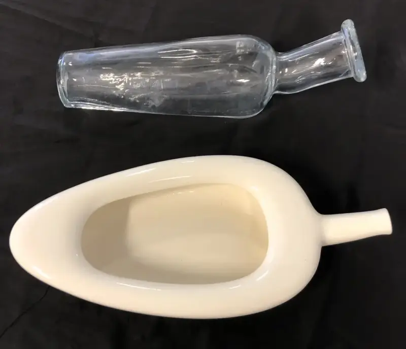 Bildet viser en avlang glassflaske og en kremhvit avlang gjenstand med åpning og tut