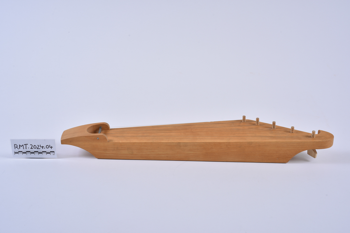 Femstrengs kantele skåret ut av ett stykke tre.
