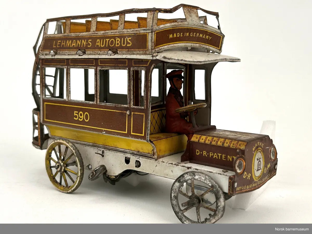 En lekebuss med vindeltrapp bak, og sjåfør med hatt fremme. det er en to etasjes buss, med åpen tak på toppen.  Bussen er opptrekkbar.