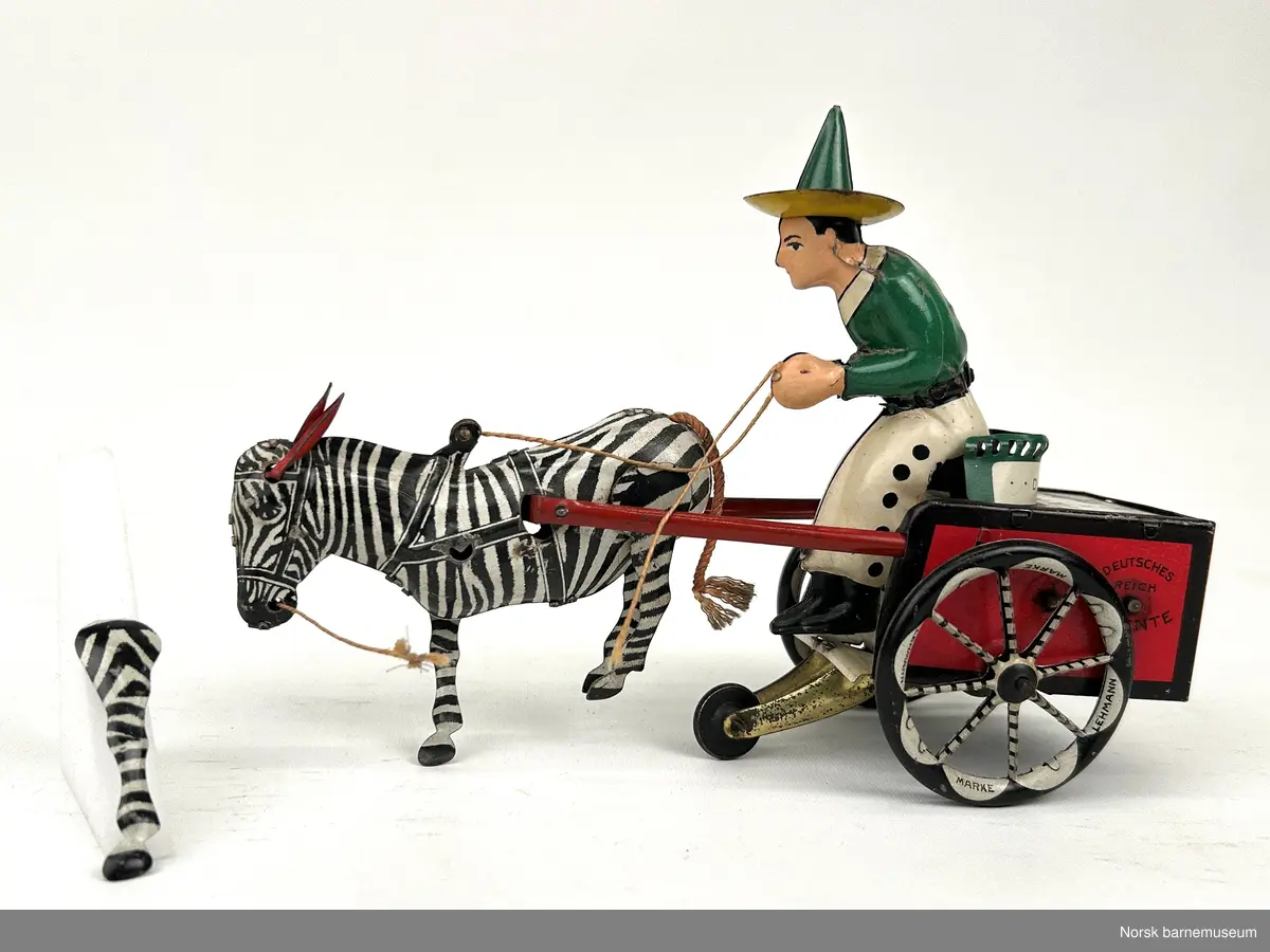 En mann med sombrero sitter på en vogn som blir dratt av en zebra.