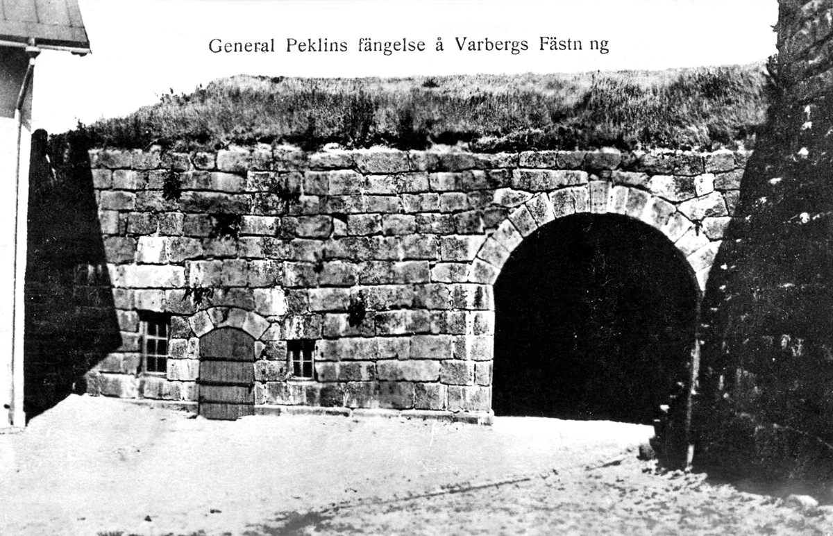 Vykort, "General Peklins fängelse å Fästningen". Det finns en skröna om att generalmajoren Carl Fredrik Pechlin (1720-1796), som dog på Varbergs fästning, skulle ha suttit i källarhålan dit den lilla porten på bilden leder. Sanningen är att hans tid (1792-1796) som "bekännelsefånge" på fästningen var mer bekväm. Han fick bo i Kommendanthuset och ha både betjänt och ett par av sina pigor från sitt gods Ålhult i Småland till att passa upp honom. Han tilläts även gå ner till staden. Långt fram i tiden blev han namngivare till "Pechlins gränd" i södra delen av centralorten Varberg. En minnesplatta på torget söder om kyrkan utmärker hans gravplats, som påträffades invid dåvarande kyrkogårdsmuren först 1858.

Pechlin var med all säkerhet en av de främsta konspiratörerna bakom mordet på Gustav III, men detta förnekade han. Han dömdes av Högsta domstolen att insättas på bekännelse, alltså att hållas fängslad till han bekände, först på Karlstens och därefter på Varbergs fästning, där han förblev till sin död.