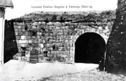 Vykort, "General Peklins fängelse å Fästningen". Det finns en skröna om att generalmajoren Carl Fredrik Pechlin (1720-1796), som dog på Varbergs fästning, skulle ha suttit i källarhålan dit den lilla porten på bilden leder. Sanningen är att hans tid (1792-1796) som "bekännelsefånge" på fästningen var mer bekväm. Han fick bo i Kommendanthuset och ha både betjänt och ett par av sina pigor från sitt gods Ålhult i Småland till att passa upp honom. Han tilläts även gå ner till staden. Långt fram i tiden blev han namngivare till "Pechlins gränd" i södra delen av centralorten Varberg. En minnesplatta på torget söder om kyrkan utmärker hans gravplats, som påträffades invid dåvarande kyrkogårdsmuren först 1858.

Pechlin var med all säkerhet en av de främsta konspiratörerna bakom mordet på Gustav III, men detta förnekade han. Han dömdes av Högsta domstolen att insättas på bekännelse, alltså att hållas fängslad till han bekände, först på Karlstens och därefter på Varbergs fästning, där han förblev till sin död.