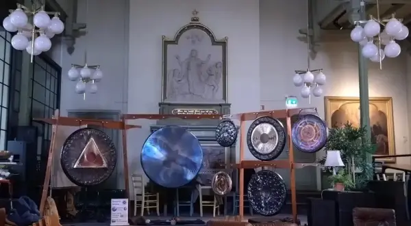 Et kirkerom med en tegning av Jesu oppstandelse i svart-hvitt og sju runde gonger i ulike størrelser hengt opp på stativer for å gi god lyd.