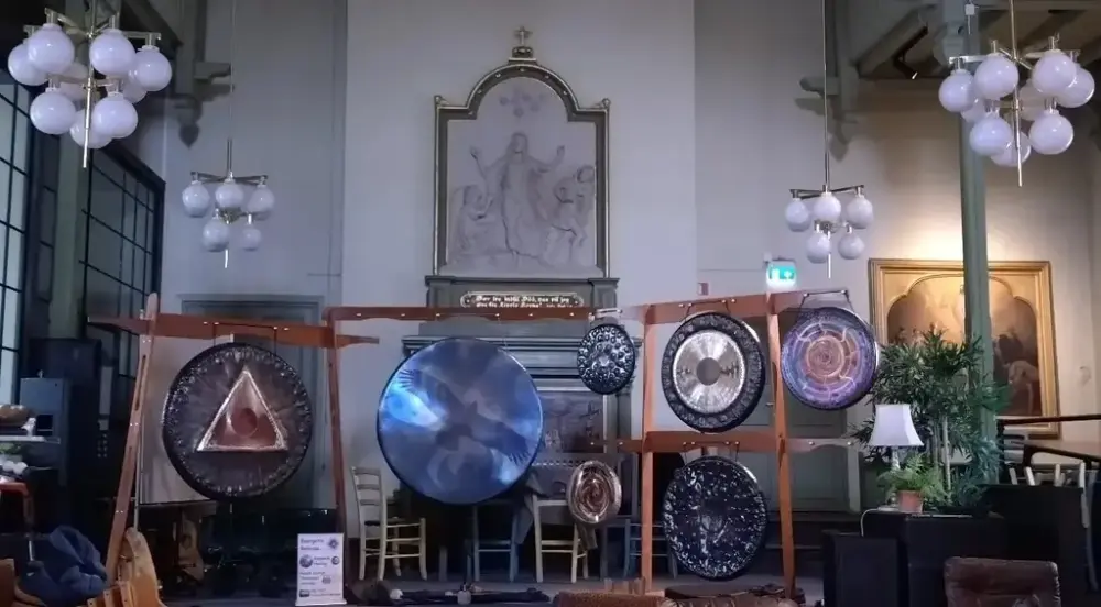 Et kirkerom med en tegning av Jesu oppstandelse i svart-hvitt og sju runde gonger i ulike størrelser hengt opp på stativer for å gi god lyd.