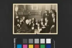 En gruppe på tolv menn iført mørke dresser med skjorter og s