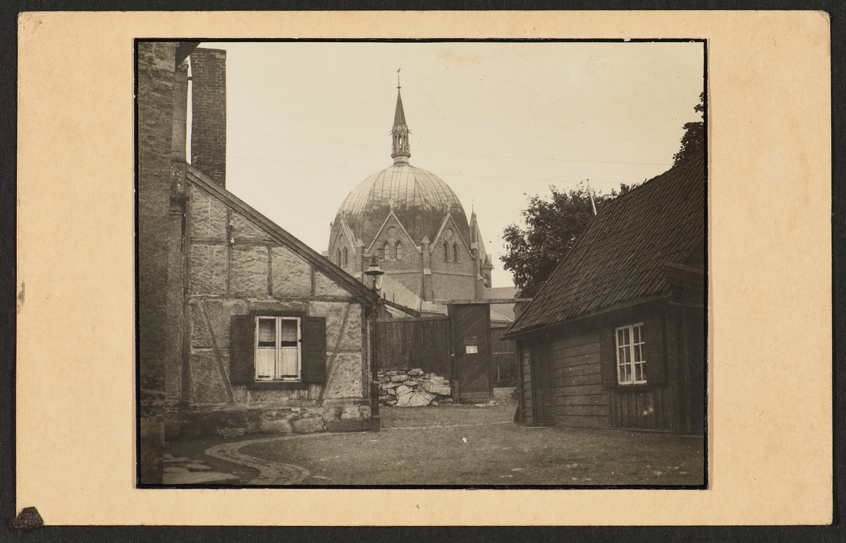 To gamle bygninger, en med bindingsverk og ett i tre med Trefoldighetskirken i bakgrunnen. Et av 17 "postkort" av samme størrelse med et bilde på hvert enkelt.