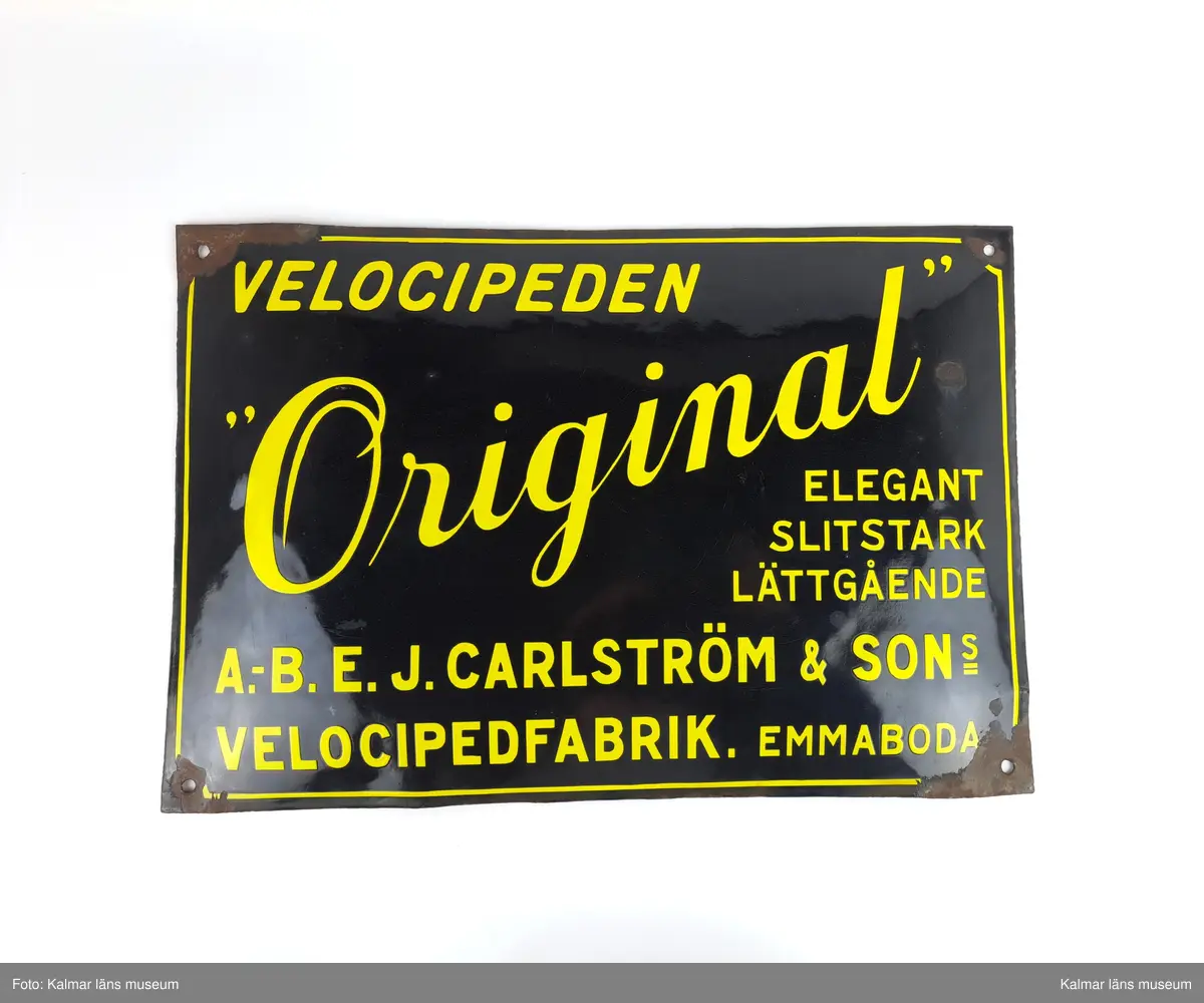 KLM 46944. Skylt. Rektangulär emaljskylt med svart bakgrund och gul text. 

Bild 2-3 (Tekniska museet): fabriken i Emmaboda samt anställda vid fabriken.