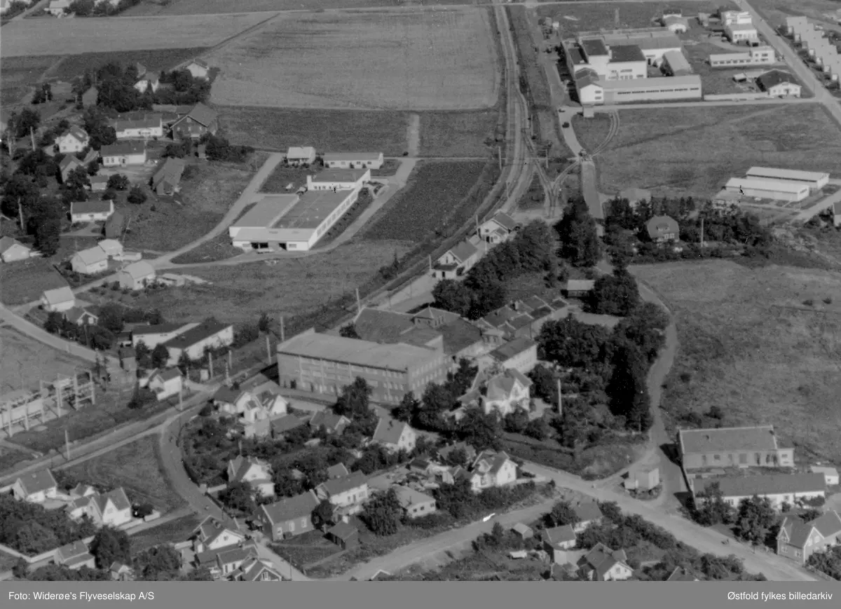 Oversiktsbilde over bolig- og industriområde, Melkefabrikken, National Industri og Sannesund stasjon i Tune i 1962.