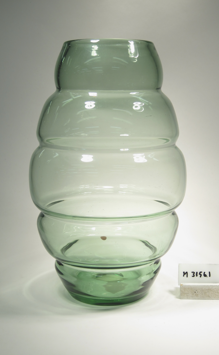 Formgivare: Edvin Ollers. Gröntonad vas med ellipsoid grundform uppdelad i fem vulster.
(Det har tidigare suttit en lapp med "212/250 m/m" på.)