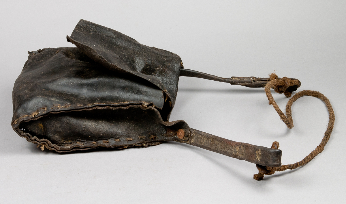 Väska i läder, med nitad axelrem av läder och rep av beckat lin. 

Funktion: Förvaring av redskap i samband med gruvarbete. I detta sammanhang tre kilar av järn SKAFÖR.0016457, SKAFÖR.0016458, SKAFÖR.001659.