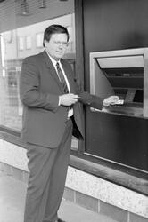 Tekst: "En ny utendørs minibank er nå montert utenfor DNC i Kristiansund. Rolf Nergaard i DNC venter at minibanken vil bli tatt i bruk i løpet av neste uke." Det skriver Nordmørsposten,  4. februar 1987. Fotograf er Jan Øivind Jensen.